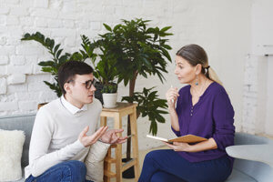 A man talks to a counselor as part of her dialectical behavioral therapy program