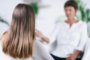 a woman talks to a counselor about a holistic therapy program