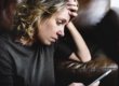 A woman sitting on the couch looking at her phone.