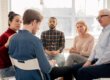 A group of people sitting in a circle talking.